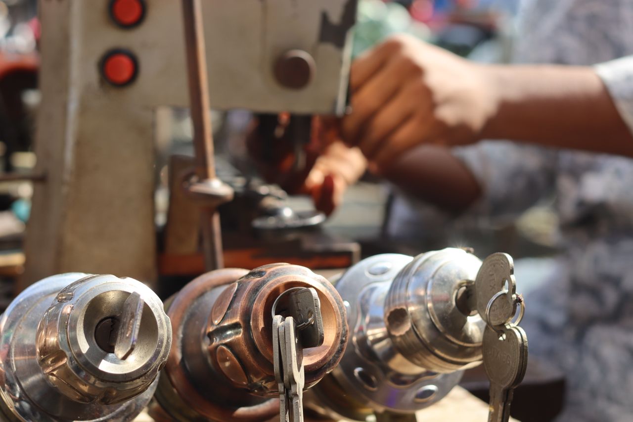 services-img Close-up image of locksmith tools and hands working with a key machine outdoors.